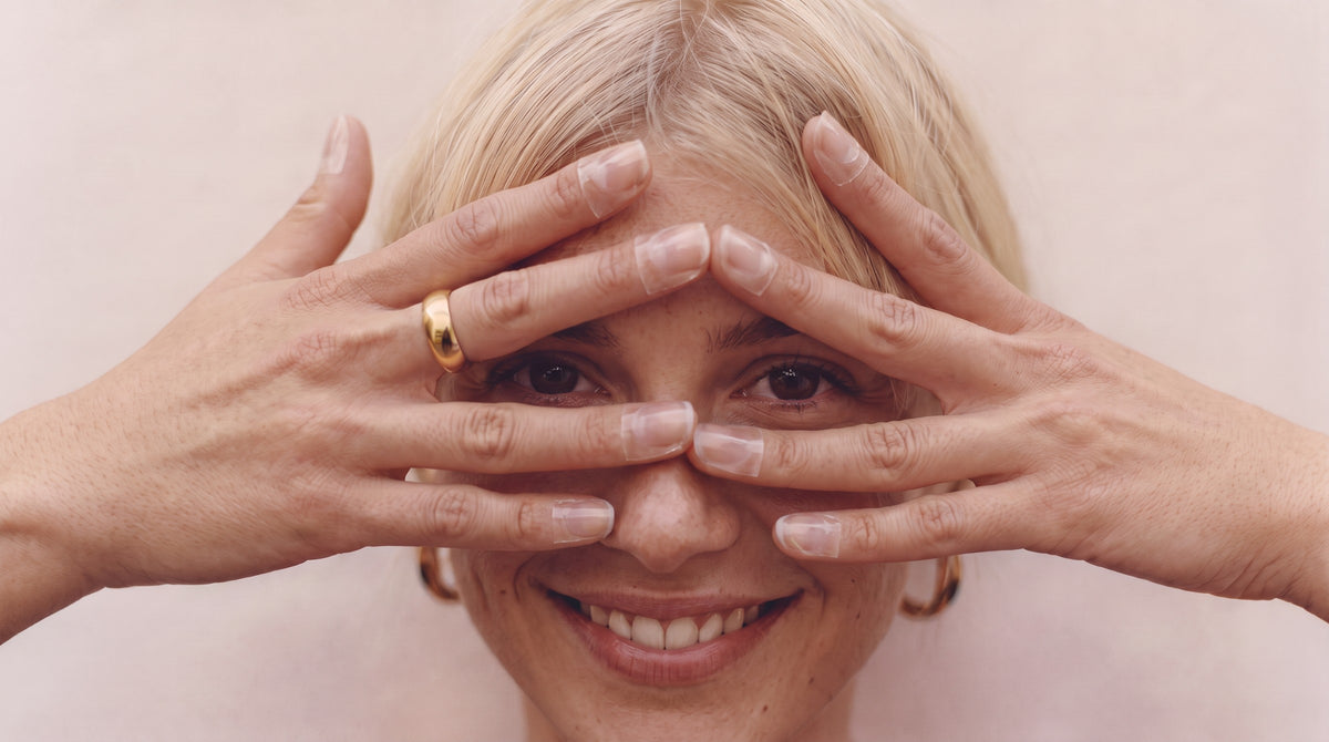 woman smiling behind her hands wearing hydronail hydrating nail masks